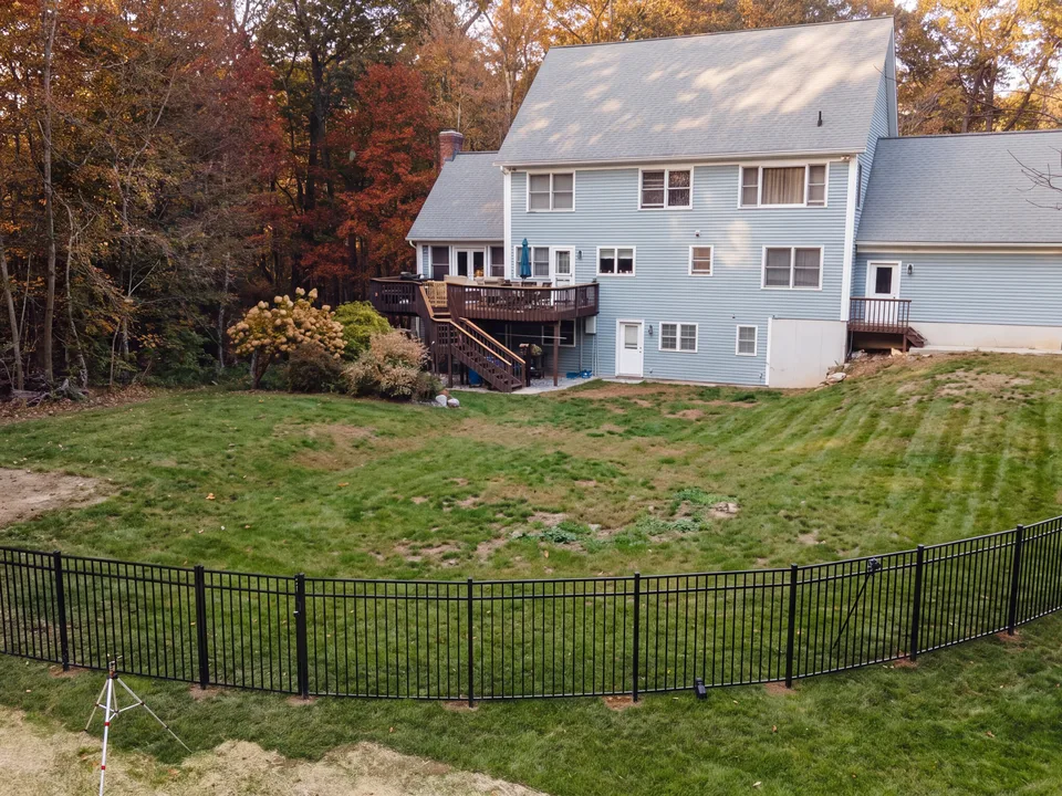 Aerial — bare backyard lawn inside a new black aluminum fence, before construction — Exterior Services LLC, Bethel, CT