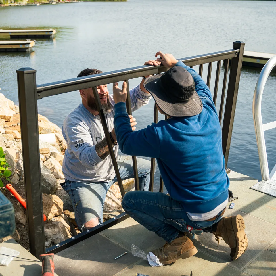 Two-man railing/fence panel install on stone — Exterior Services LLC
