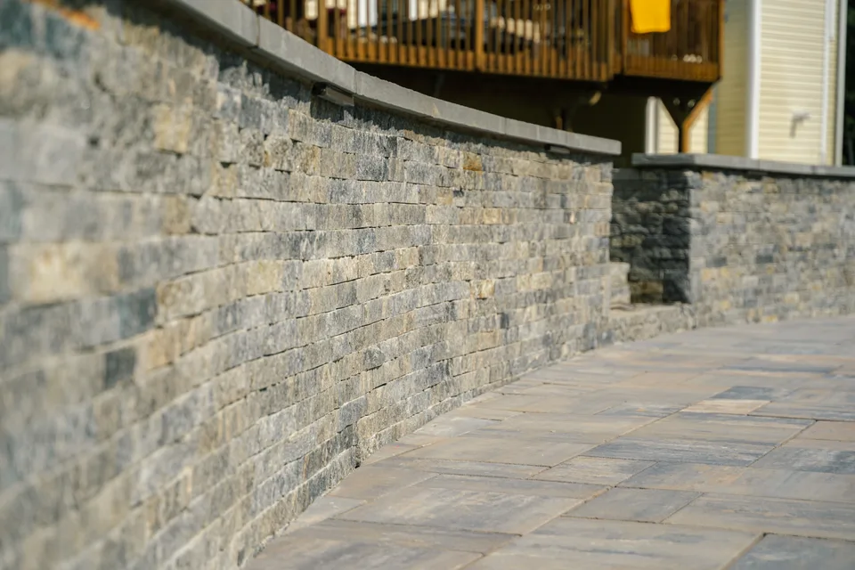 Long curved stone veneer retaining wall — Exterior Services LLC, Carmel