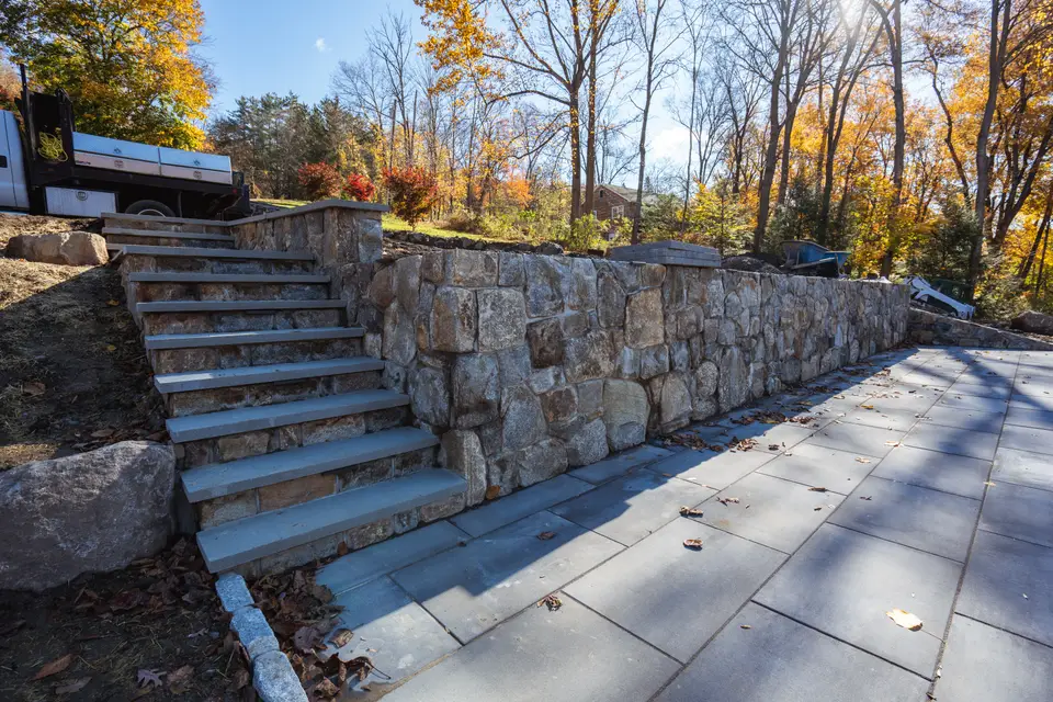 Stone steps rising through a fieldstone retaining wall — Exterior Services LLC, Sherman, CT