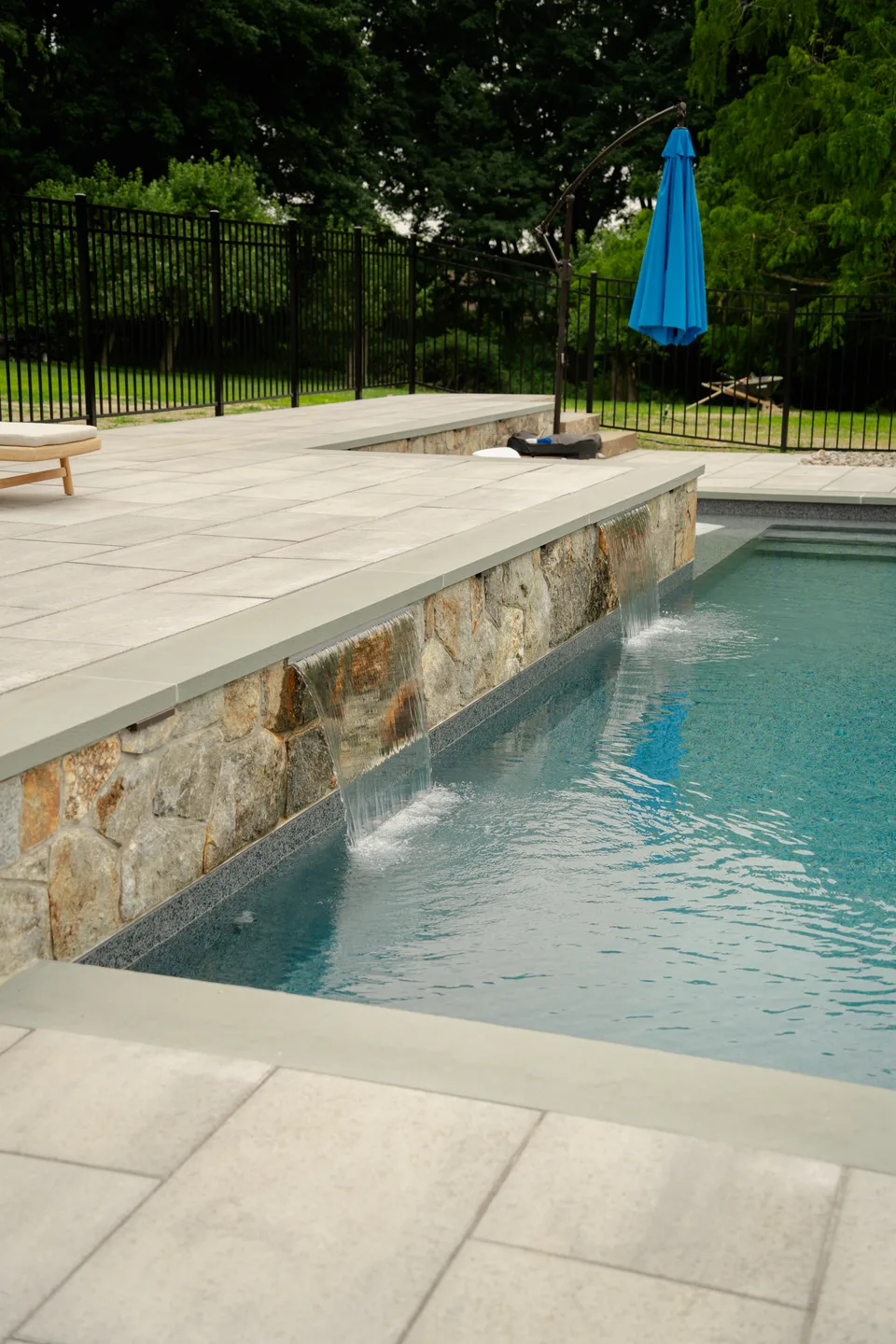 Stone veneer wall running the length of the pool — Exterior Services LLC, Brookfield, CT