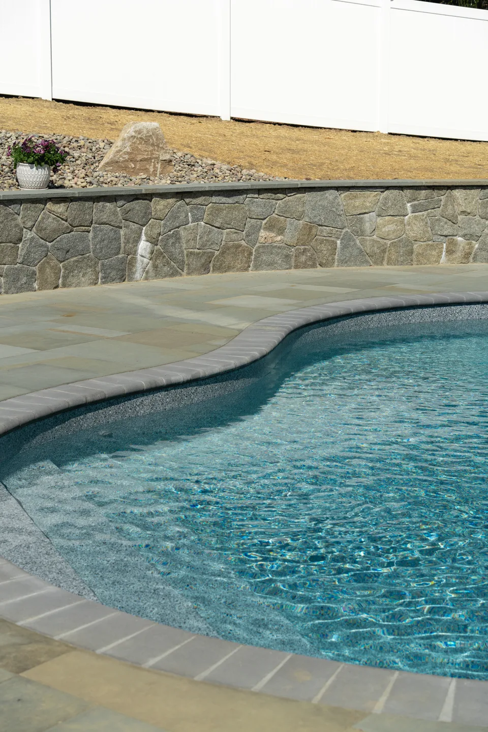 Pool coping curve and water against a fieldstone wall — Exterior Services LLC, Newtown, CT