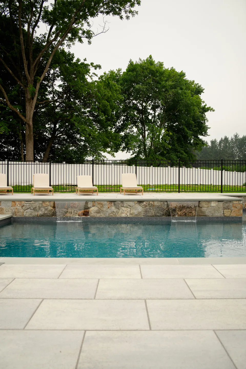 Scupper wall spilling the length of the pool, loungers above — Exterior Services LLC, Brookfield, CT